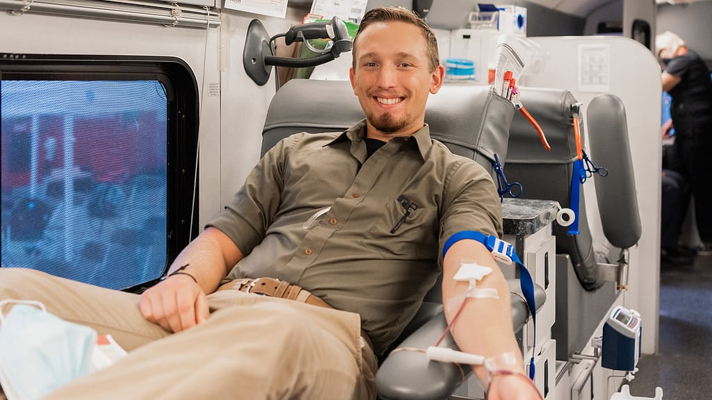 Male student donating in van