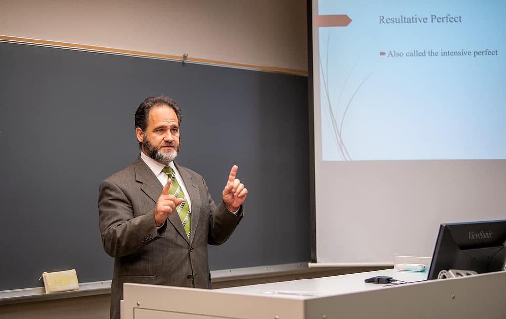 Dr. Michael Colucci standing at a podium and teaching.