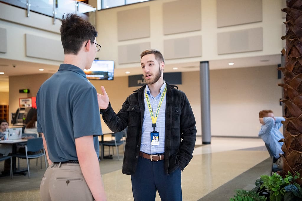 Andrew Malack speaking to a student in the PCC Commons.