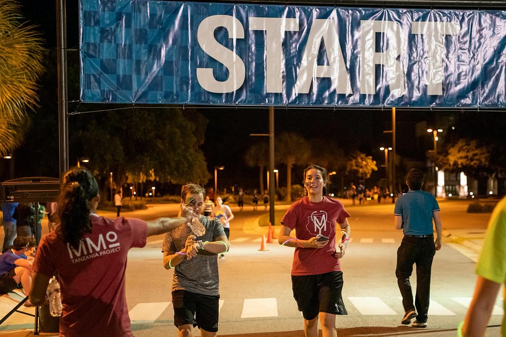 A guy and girl cross the finish line around the same time
