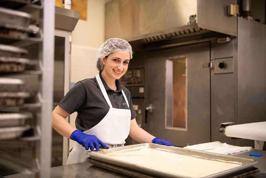 Work student Leann Sinclair bakes cookies in the Bakery