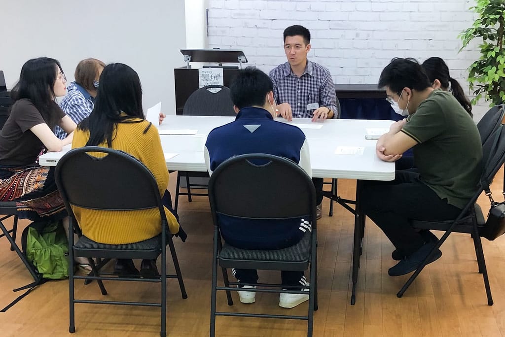 James talking to others at a table.