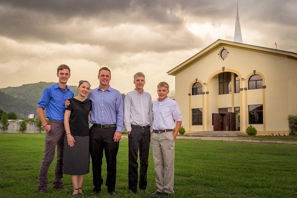 Matt and Dallita Goins with their sons in front of a church. 