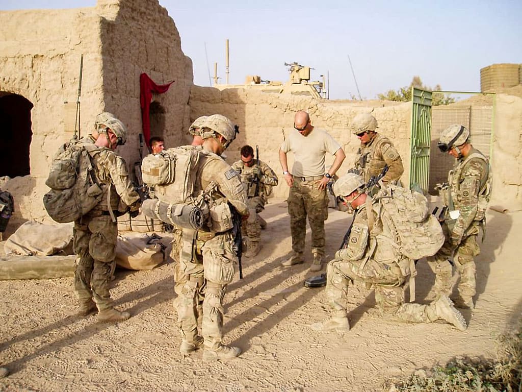 Cliff Jones praying with soldier overseas