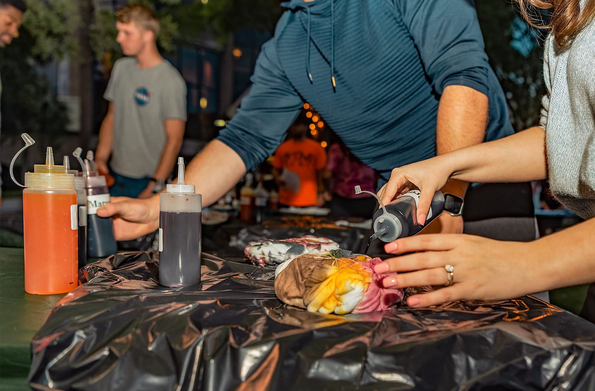 close-up of students hands tie-dying t-shirts