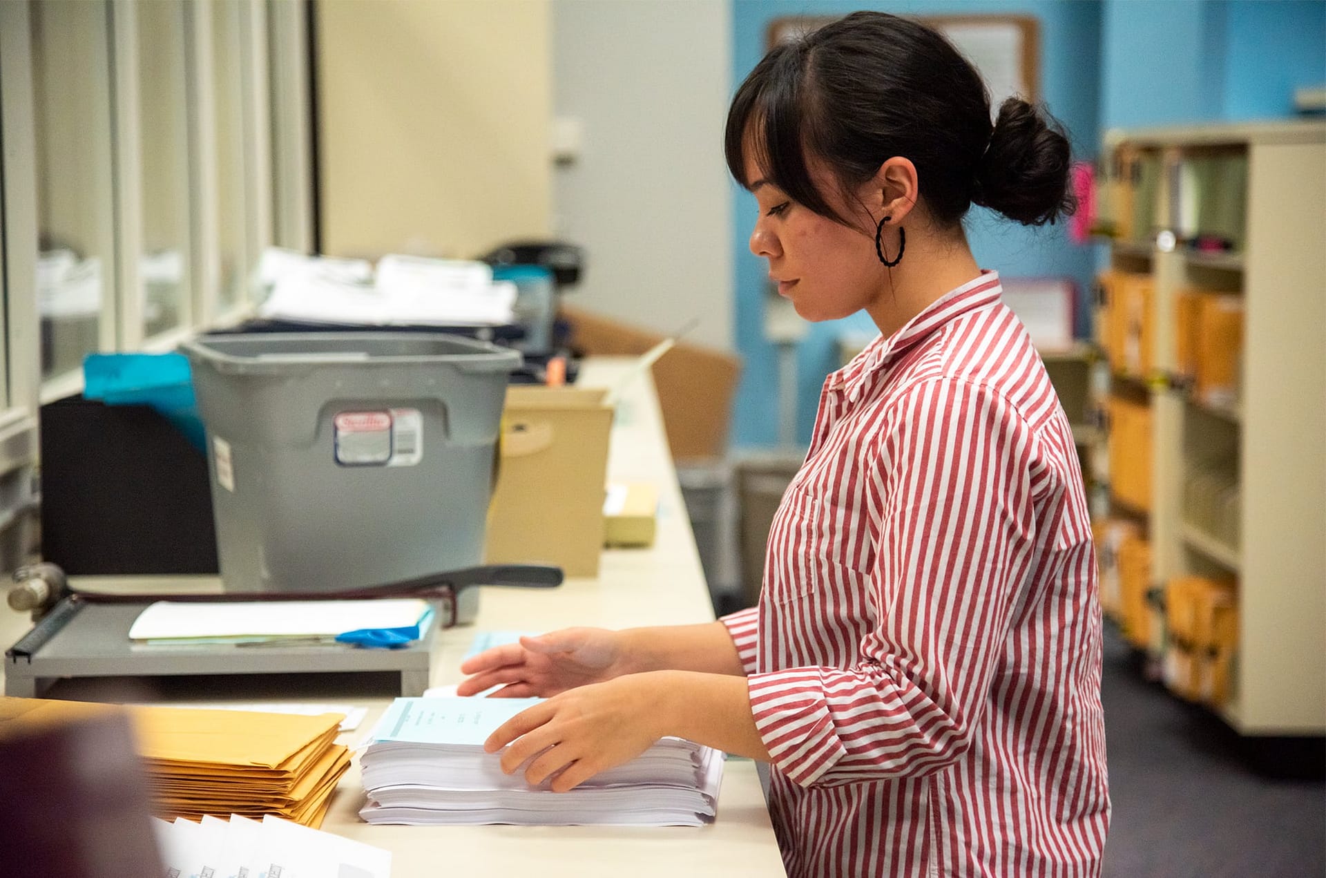 Female student abeka worker looking at papers on a table.