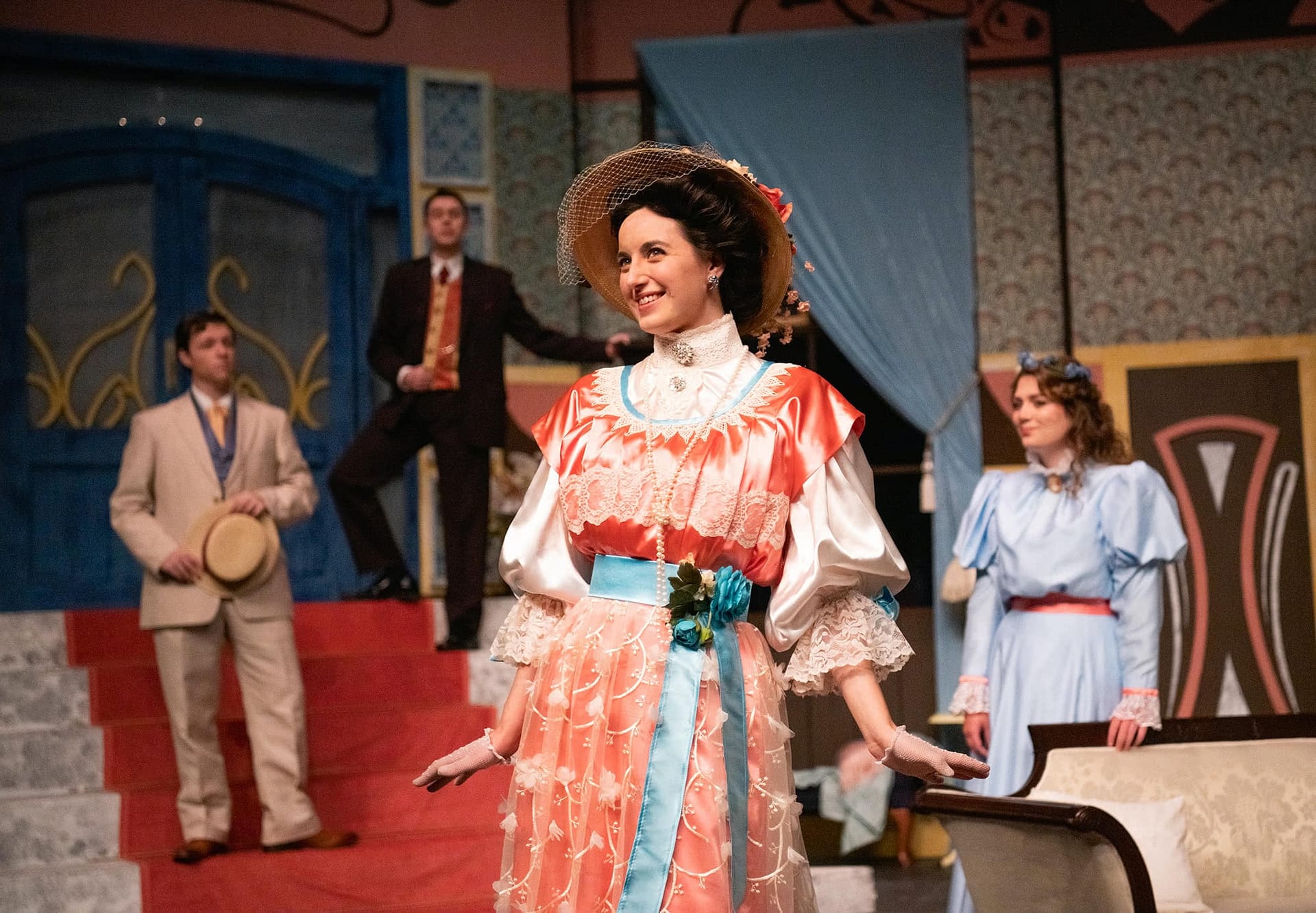 A woman in a pink dress standing and smiling. 