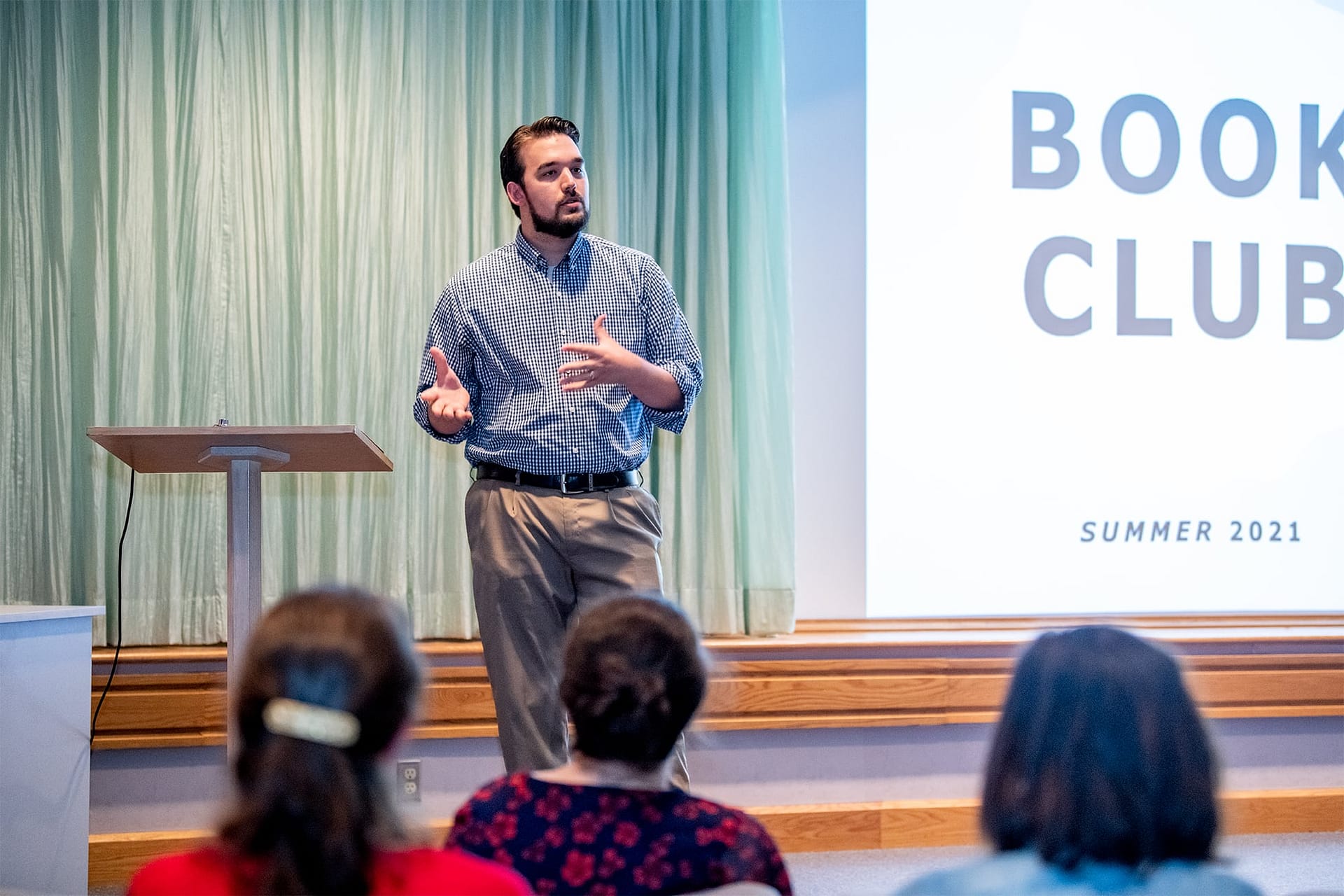 Man standing and speaking about book club.
