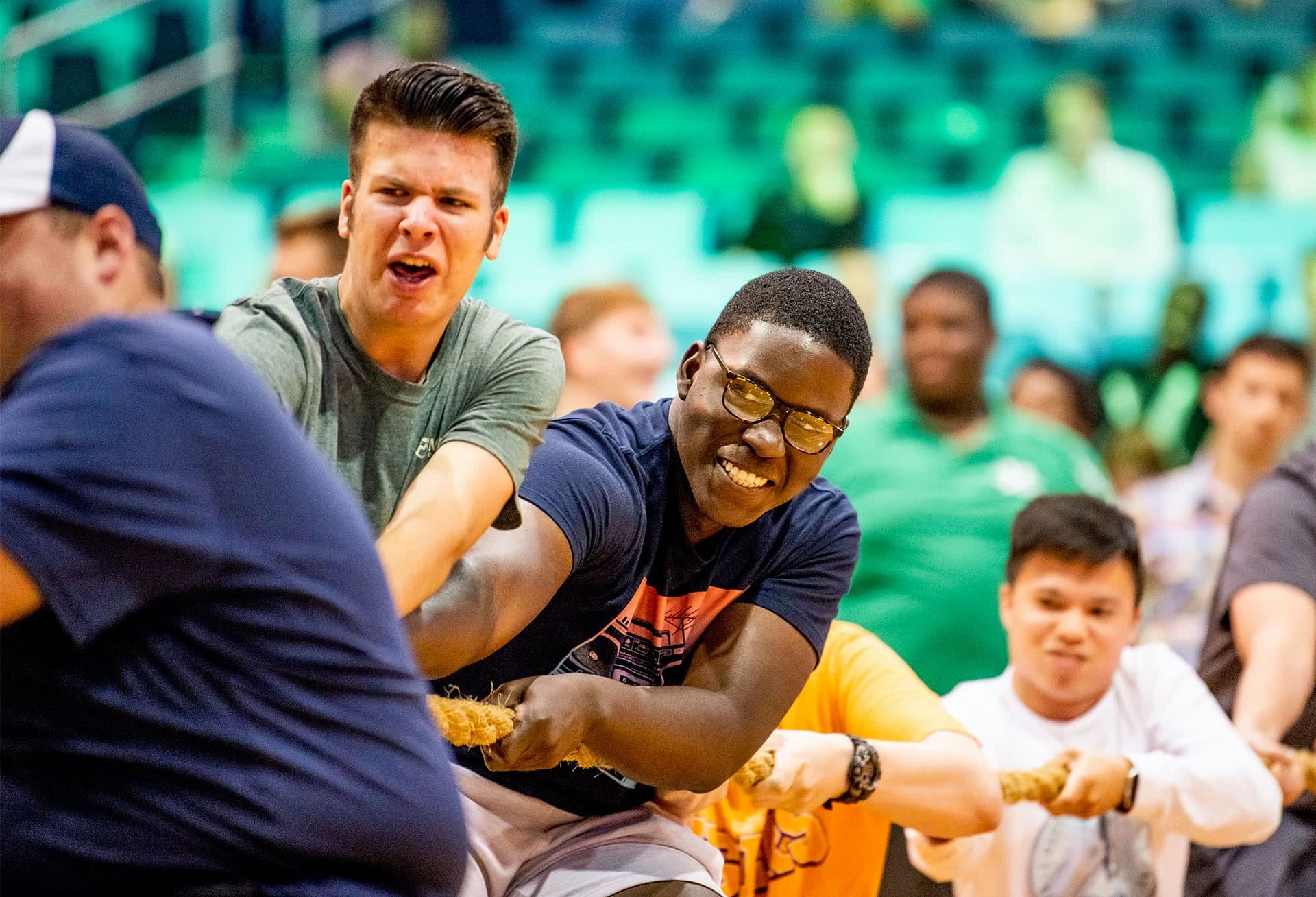 Male students pulling a rope in tug of war.