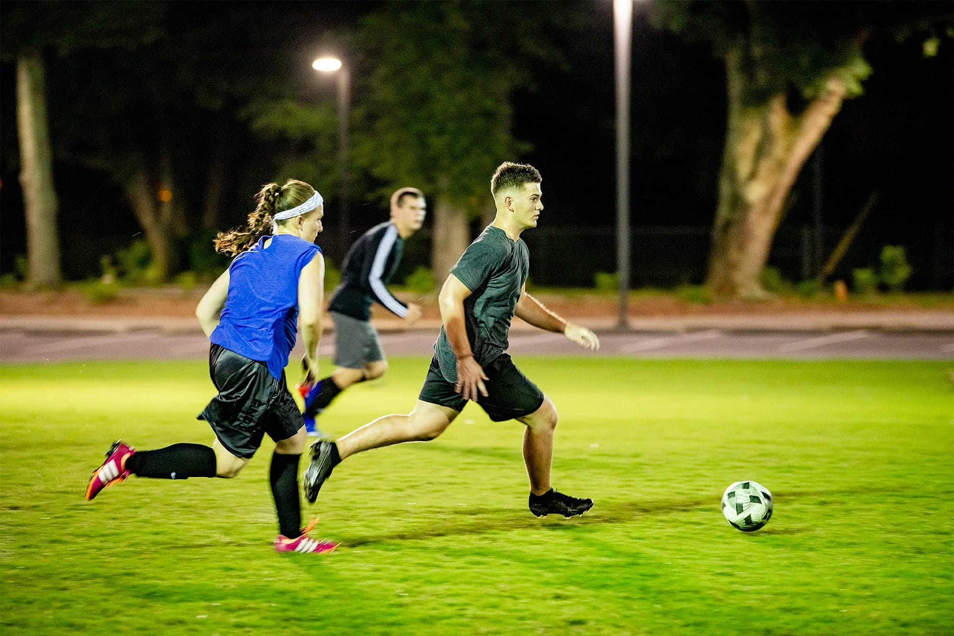 Students running after a soccer ball.