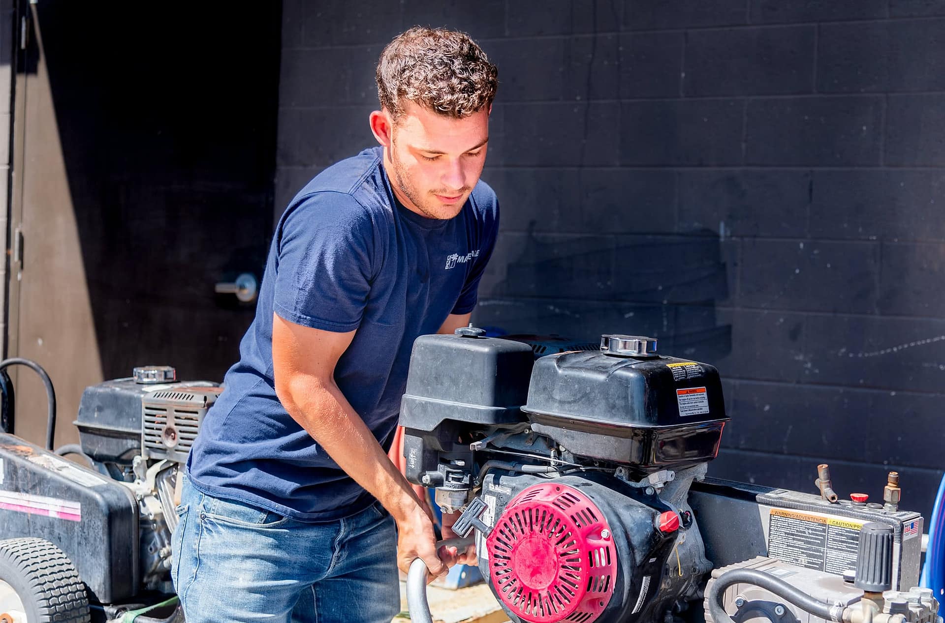 Male student worker lifting a machine.