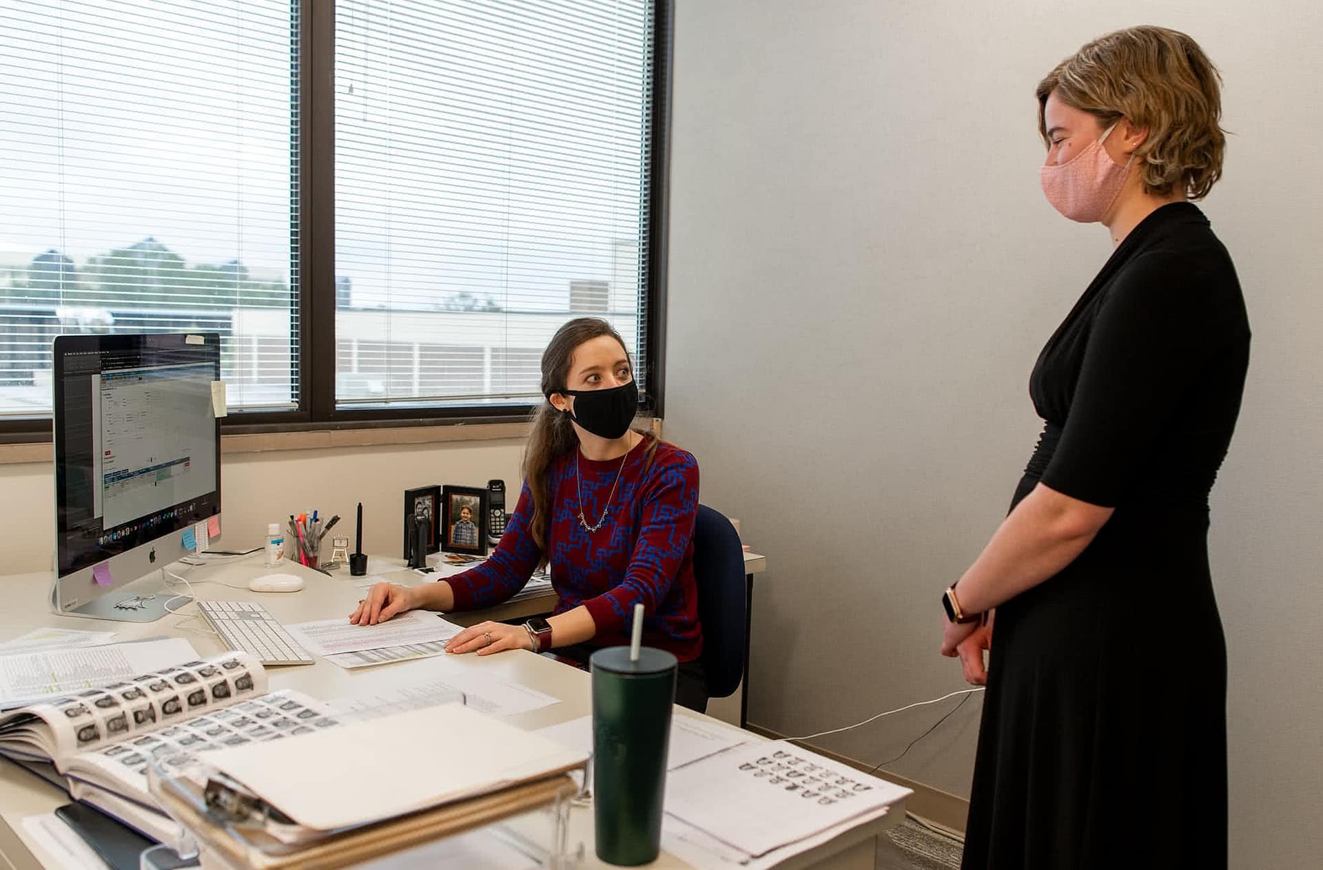 A female student and female Summit staff member talking at a desk. 