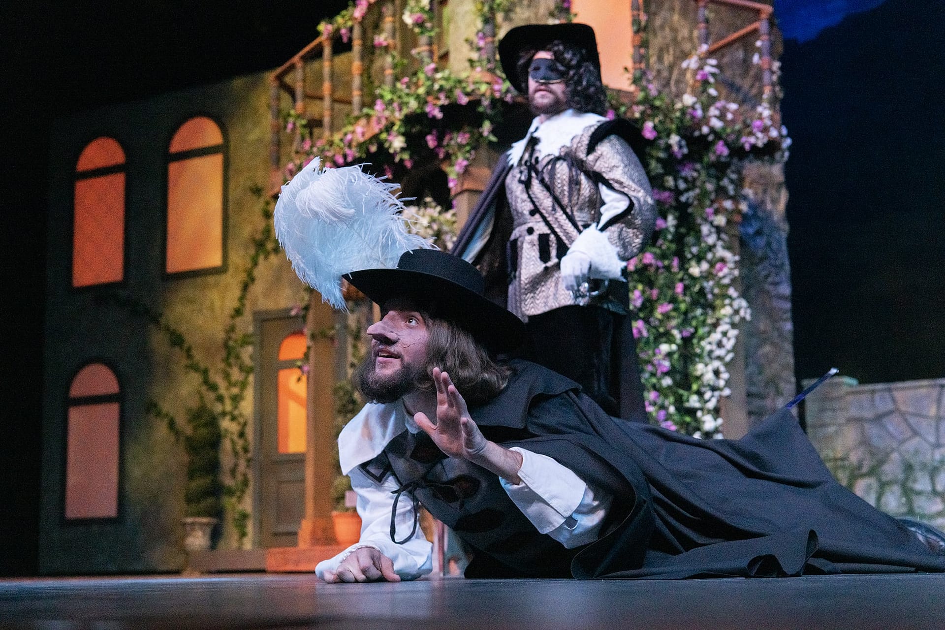 Cyrano lies on the ground talking to someone