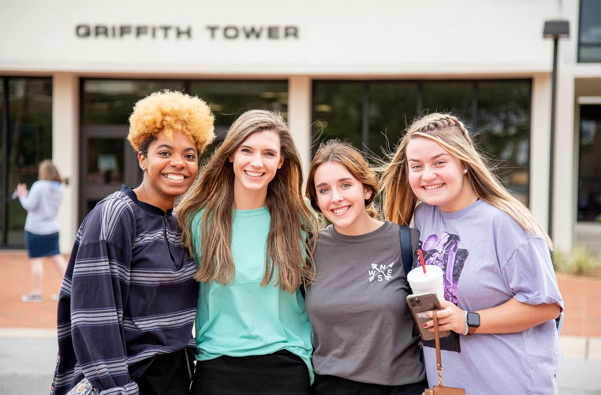 Four friends pose for a picture outside Griffith Tower