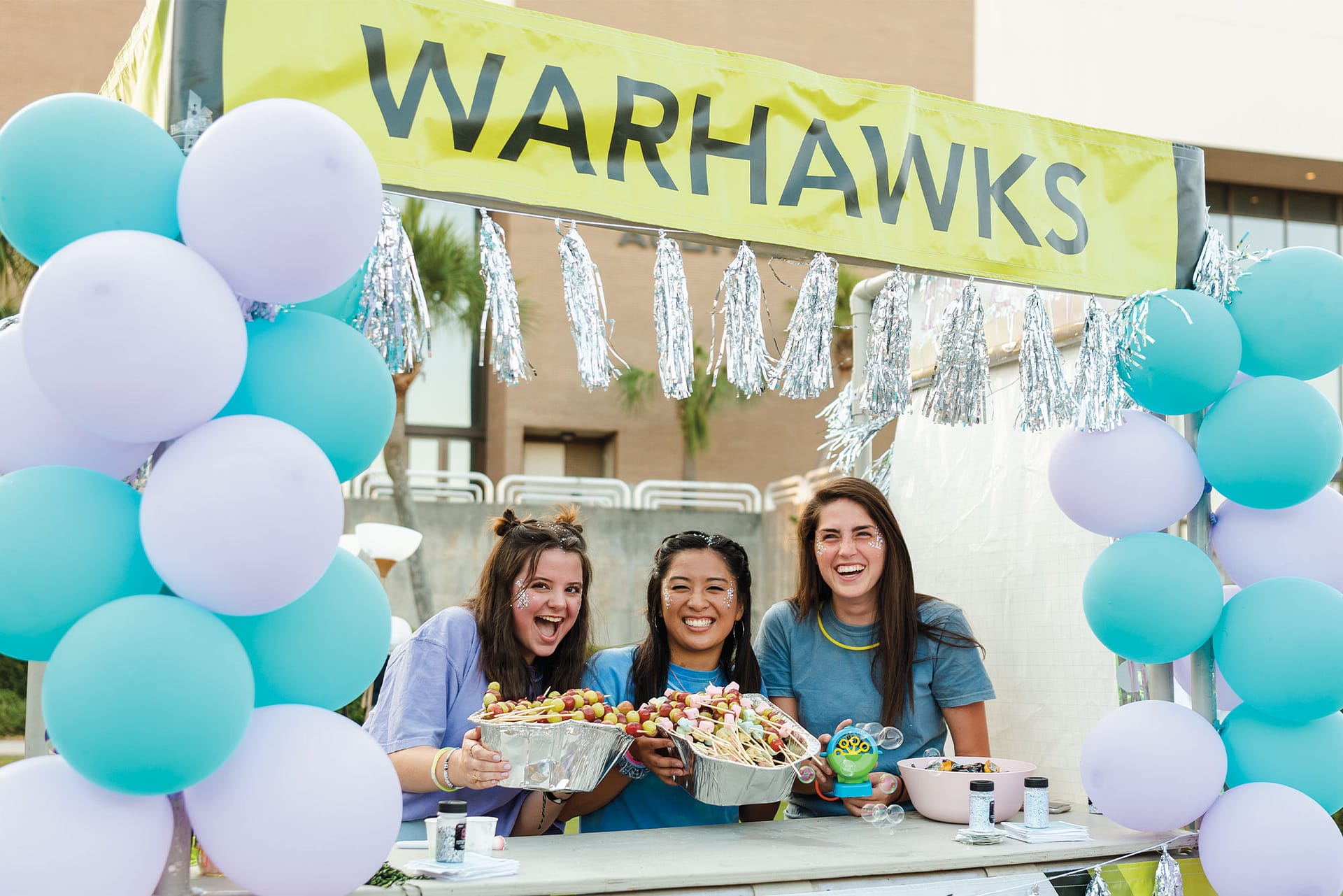 War Hawk girls at a booth during Greek Rush