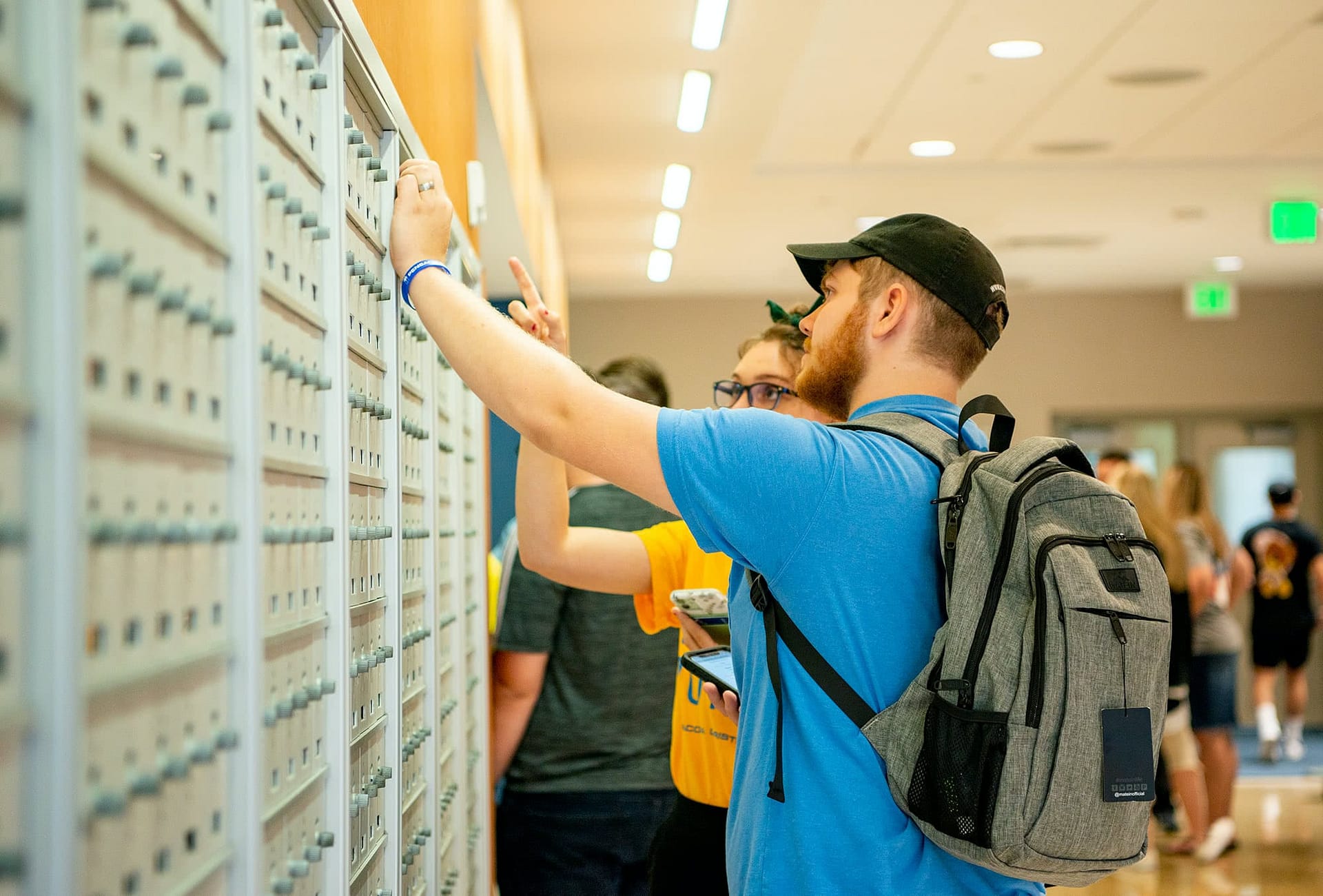 College student opening mailbox