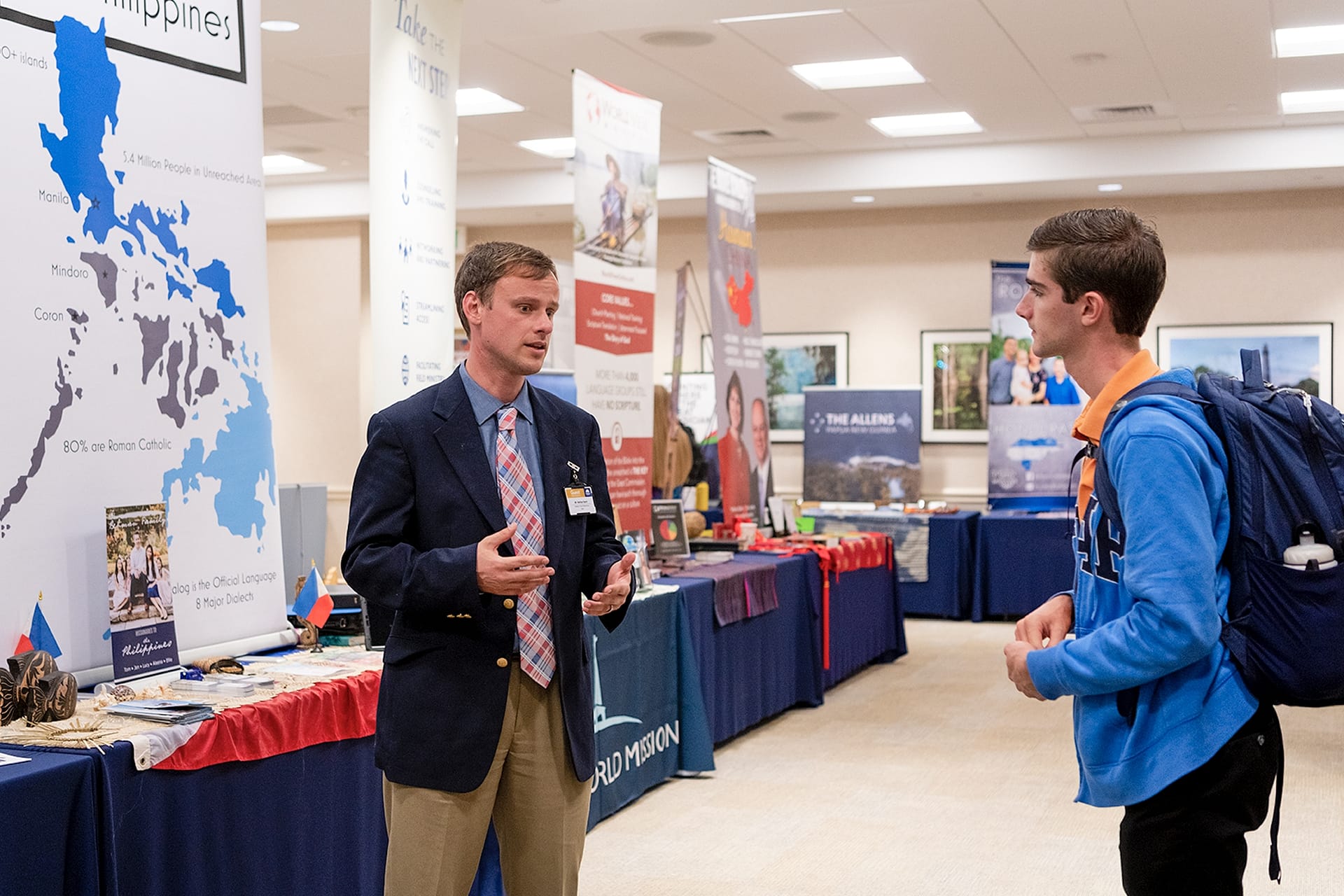 Student talking with a missionary representative at their booth..