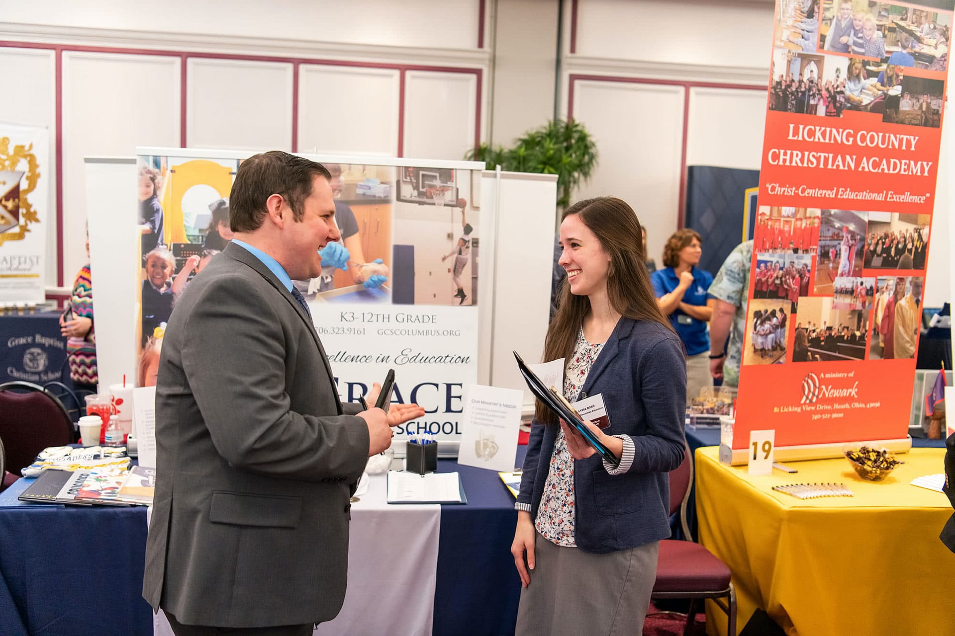 PCC senior speaking at a booth with a christian school administrator at the 2020 Educator Recruitment. 