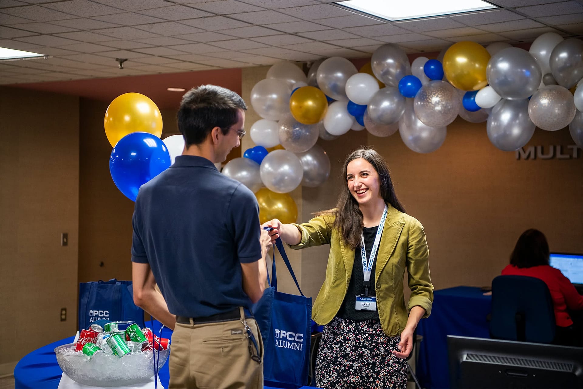 PCC Alumni handing out gift bags to another alumni.
