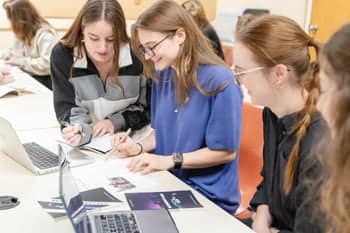 PCC students work together in class to design the cover of the 2024 Fountains Publication