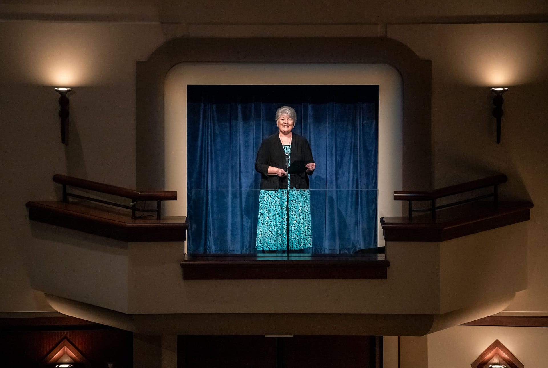 Rhonda Autrey speaking from stage balcony.