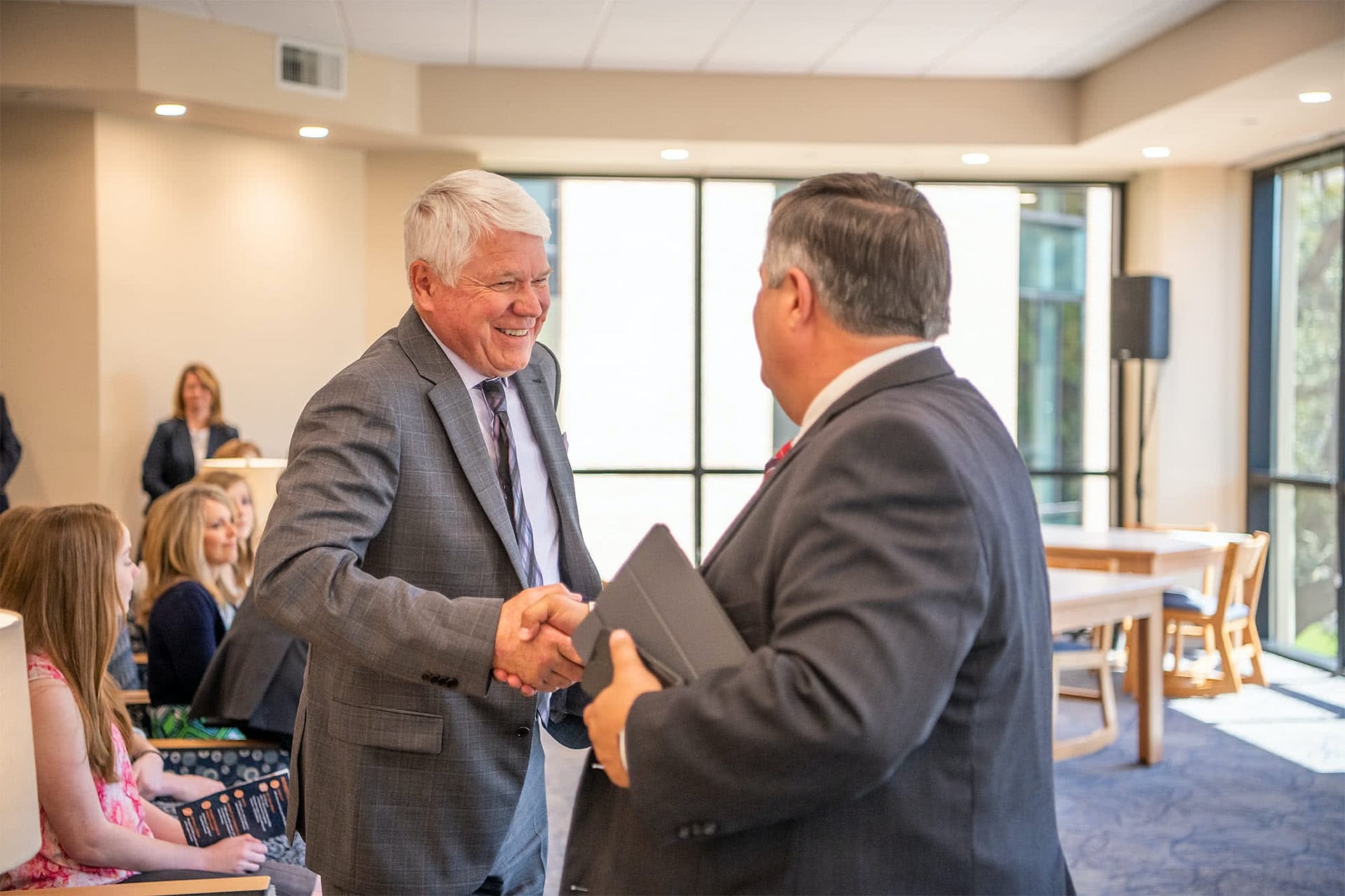Dr. Bill Rice, III shaking hands with Dr. Troy Shoemaker. 