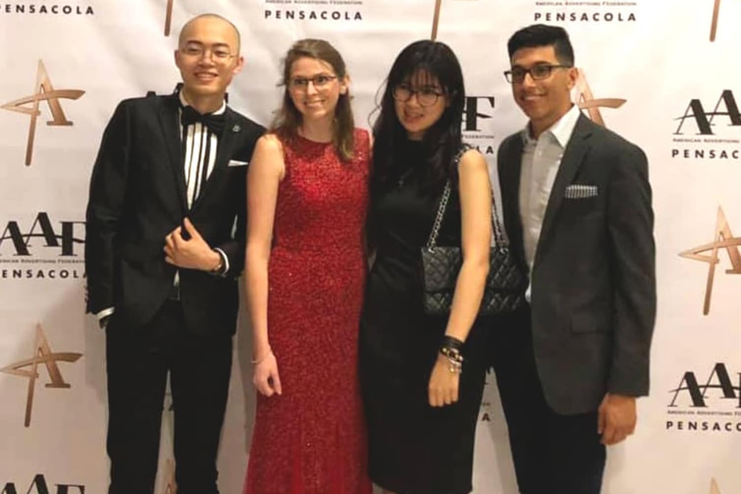 Three students pose with a female teacher