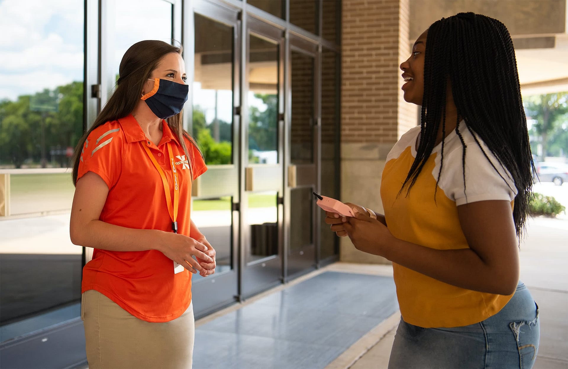 Teen Extreme camp counselor speaking with a camper. 