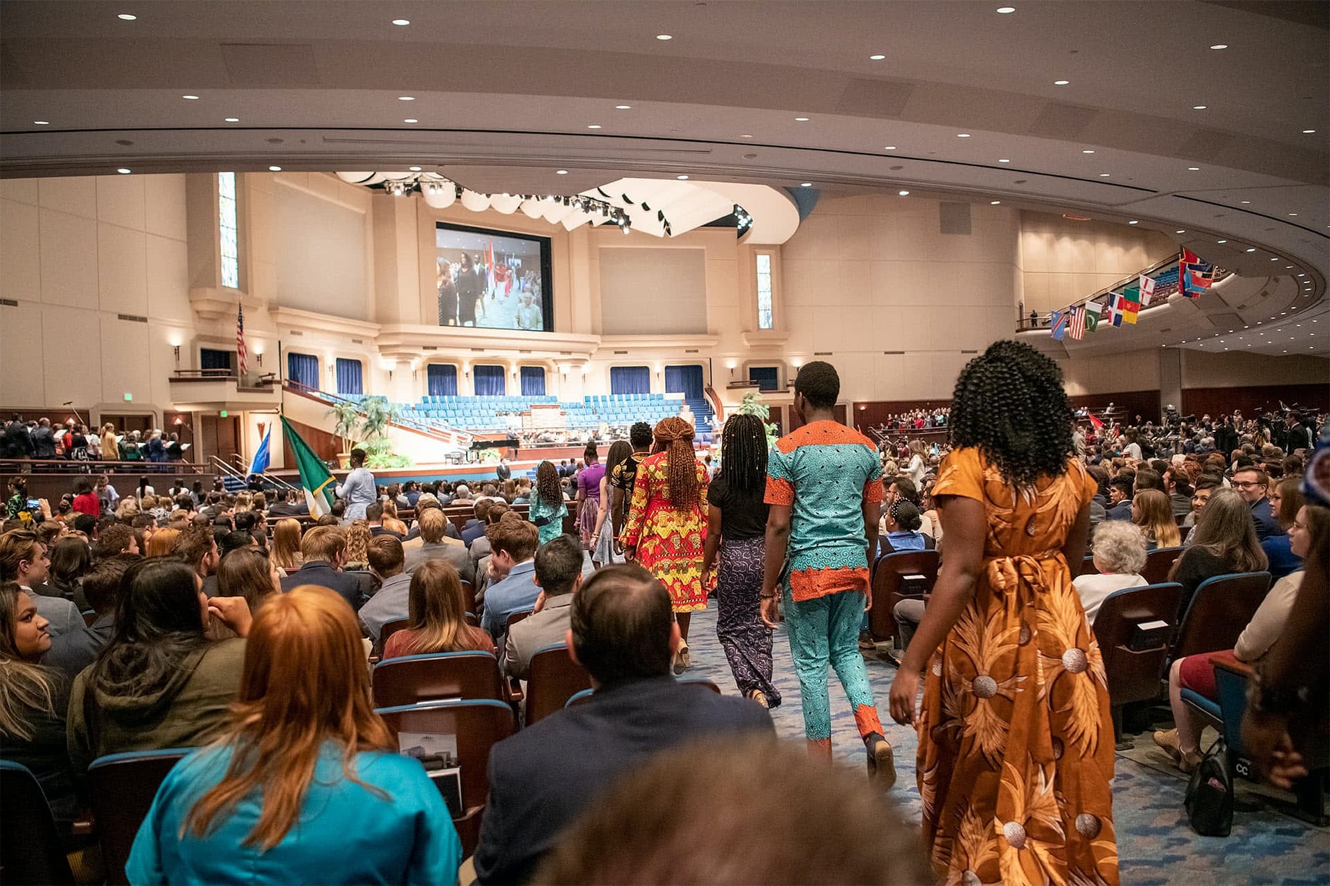PCC students walking toward the Crowne Centre stage and representing their home country in the Parade of Nations.