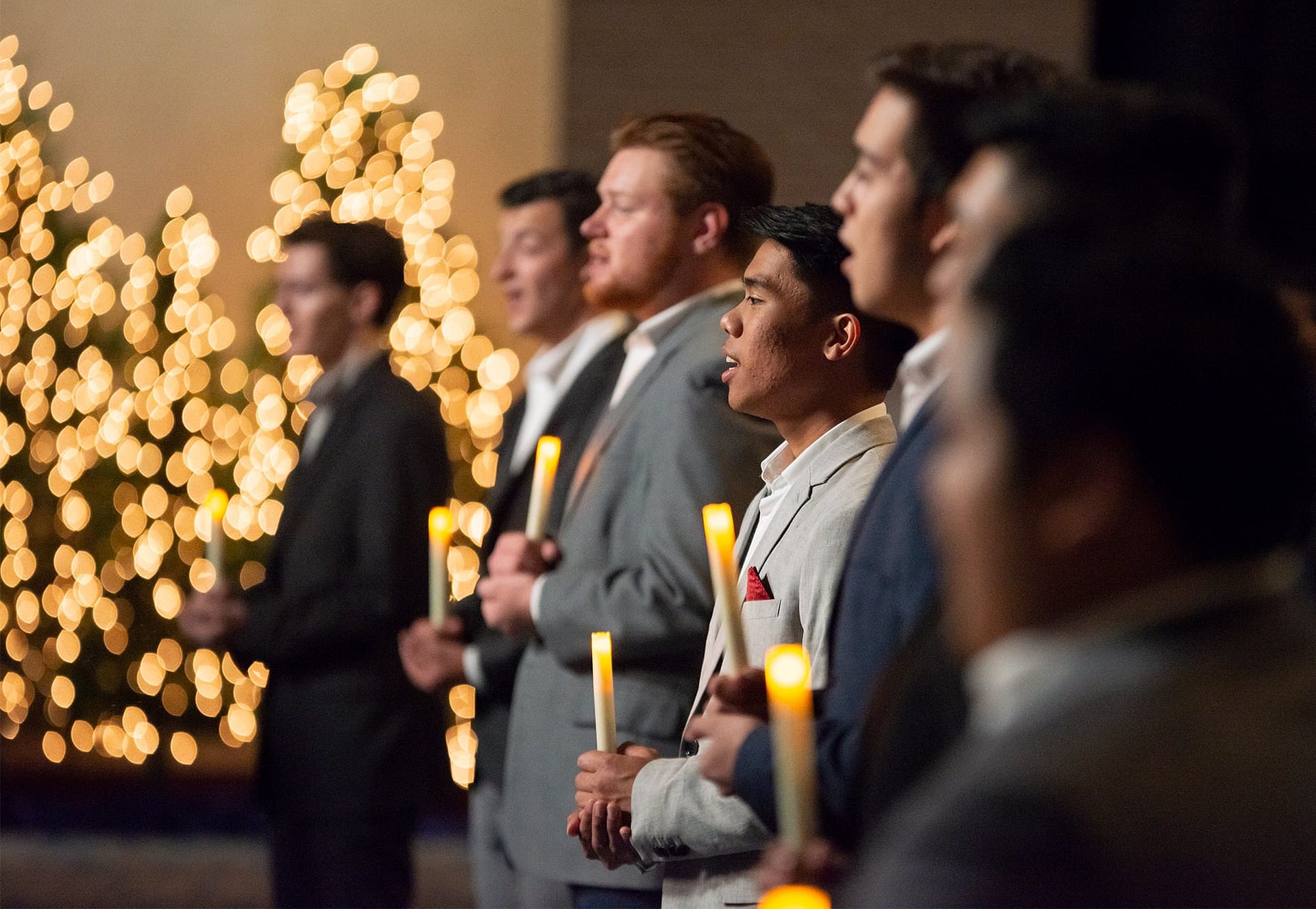 One Accord singers hold candles as they sing