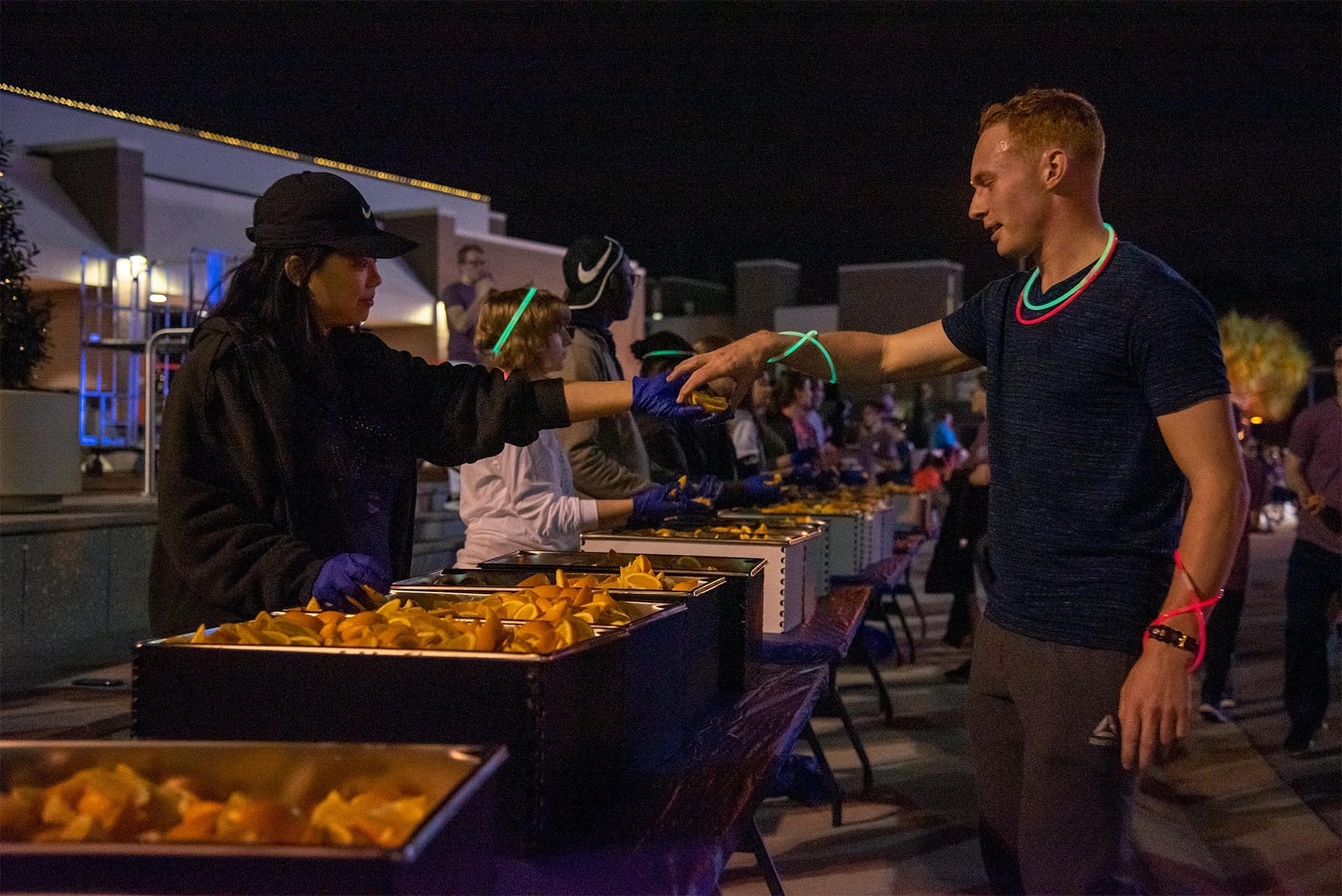 Volunteer passes out orange slices to runners after they are done