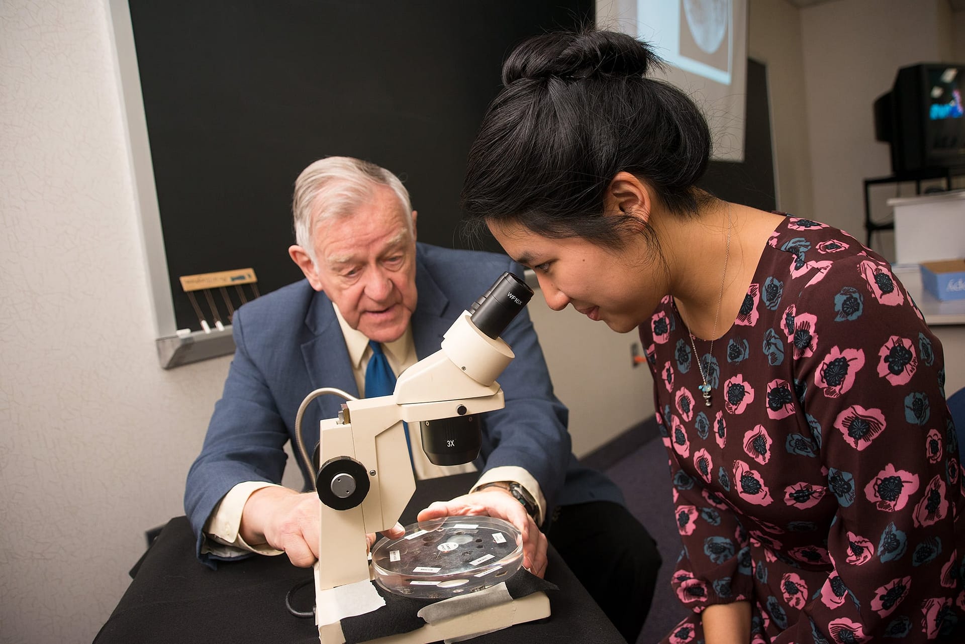 student looking in microscope.