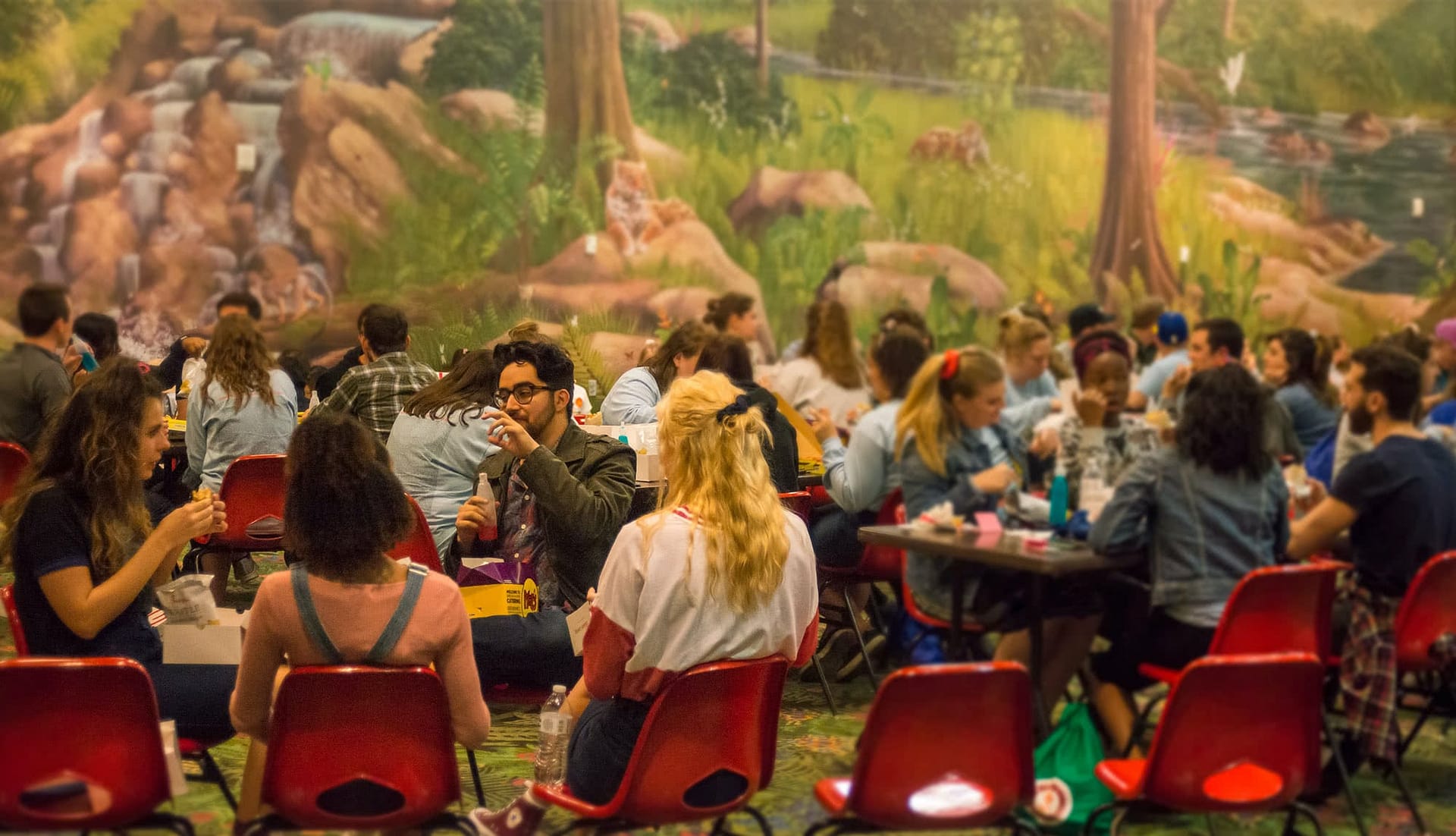 Students sitting in the Sports Center eating together.