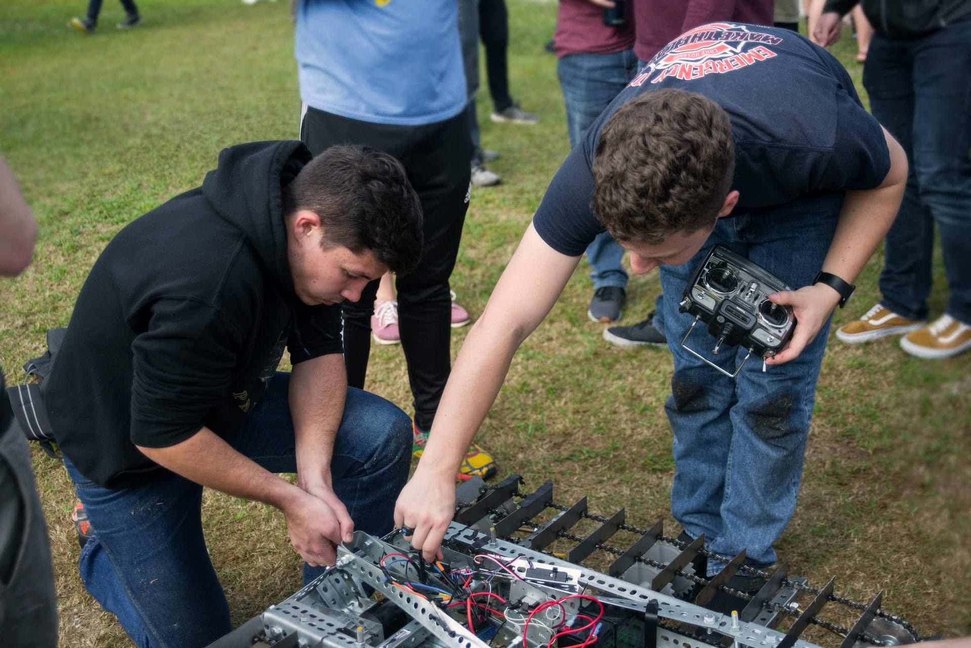 Two male students working on their team's robot for the Engineering Design Contest.