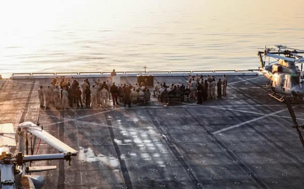 Men in the Navy standing on a ship at sea. 