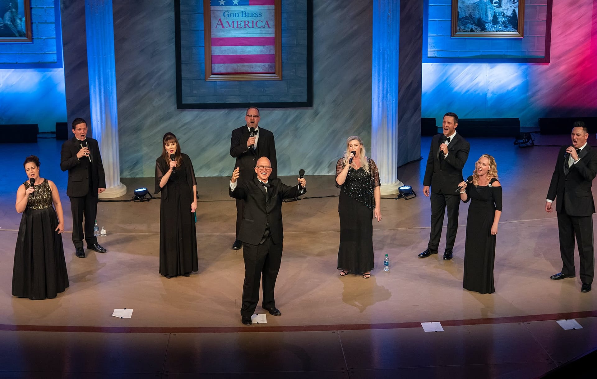 Liberty Voices standing on the PCC Crowne Centre stage and singing together.