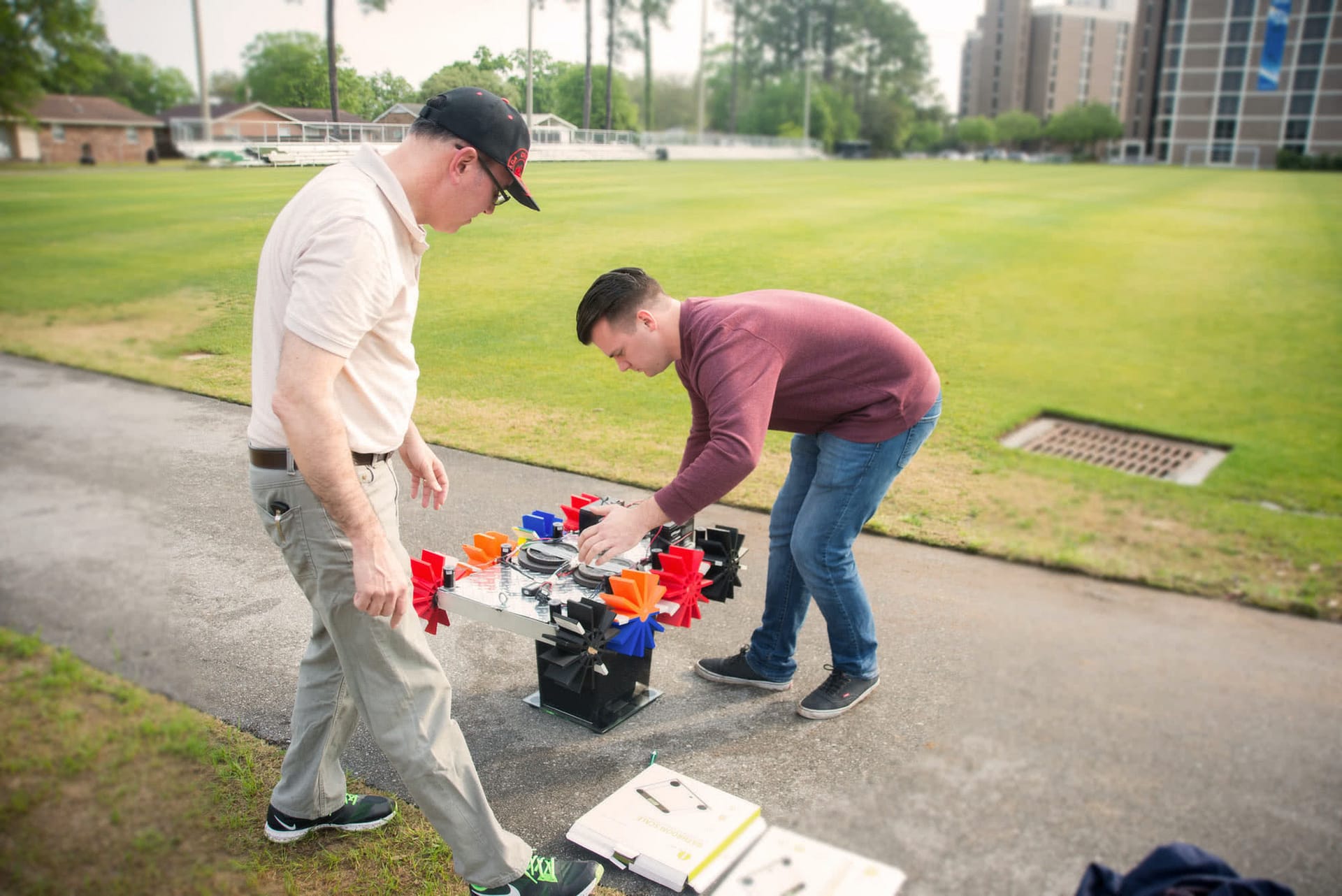 Two male students working on their robot for the Engineering Design Contest.