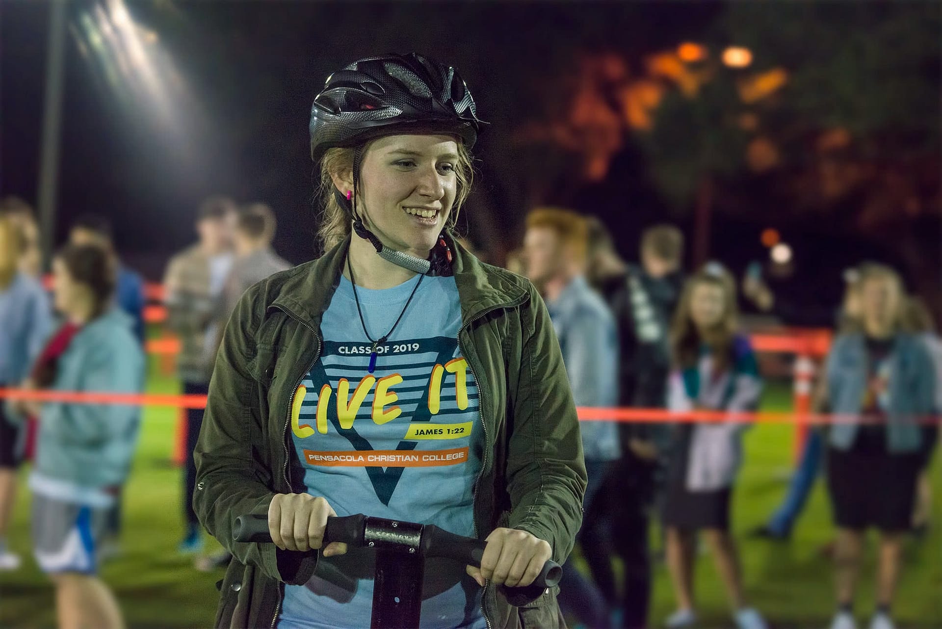 Female student wearing a helmet and riding a segway.