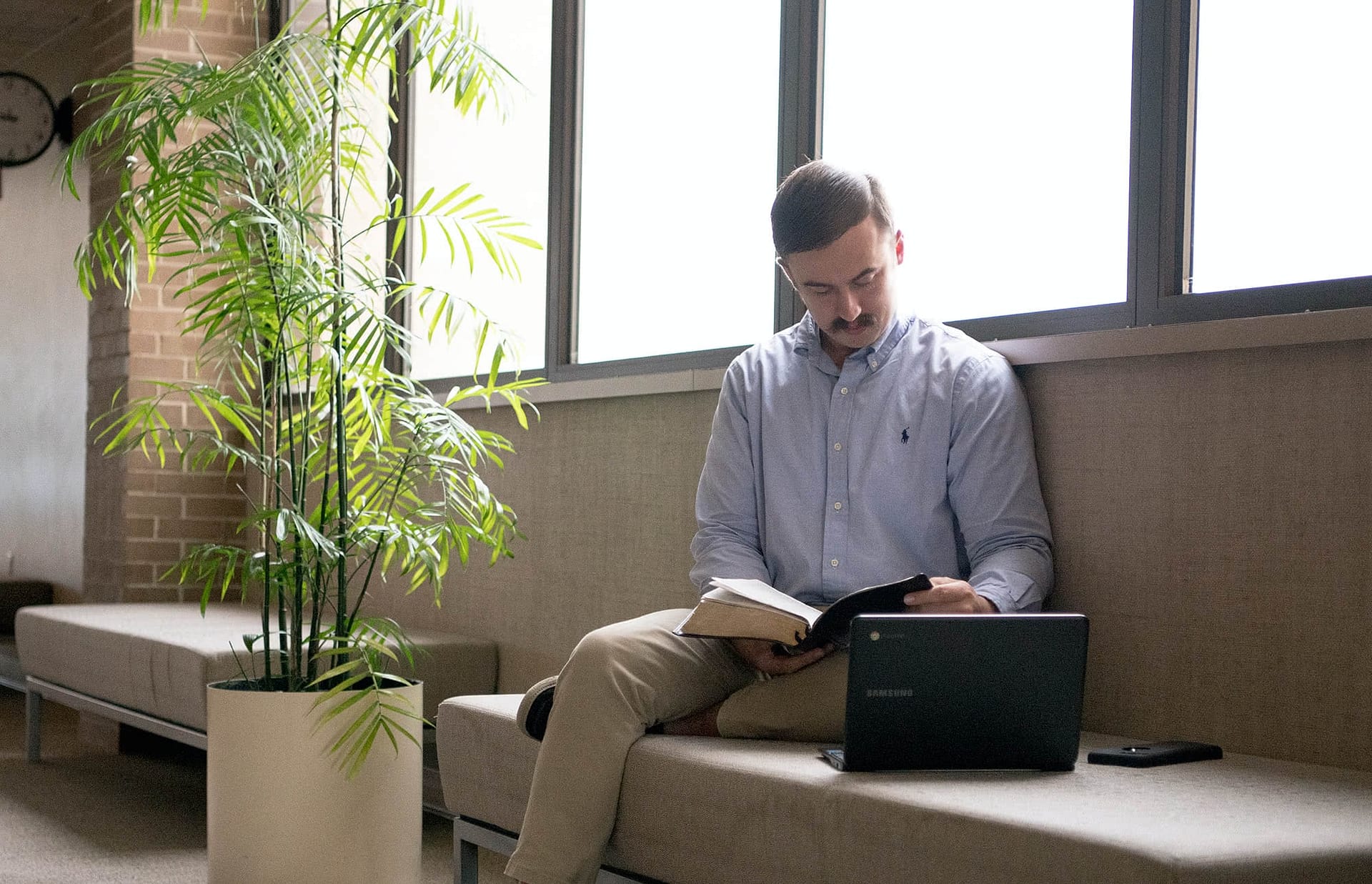 Graduate student sitting and looking at the Bible.