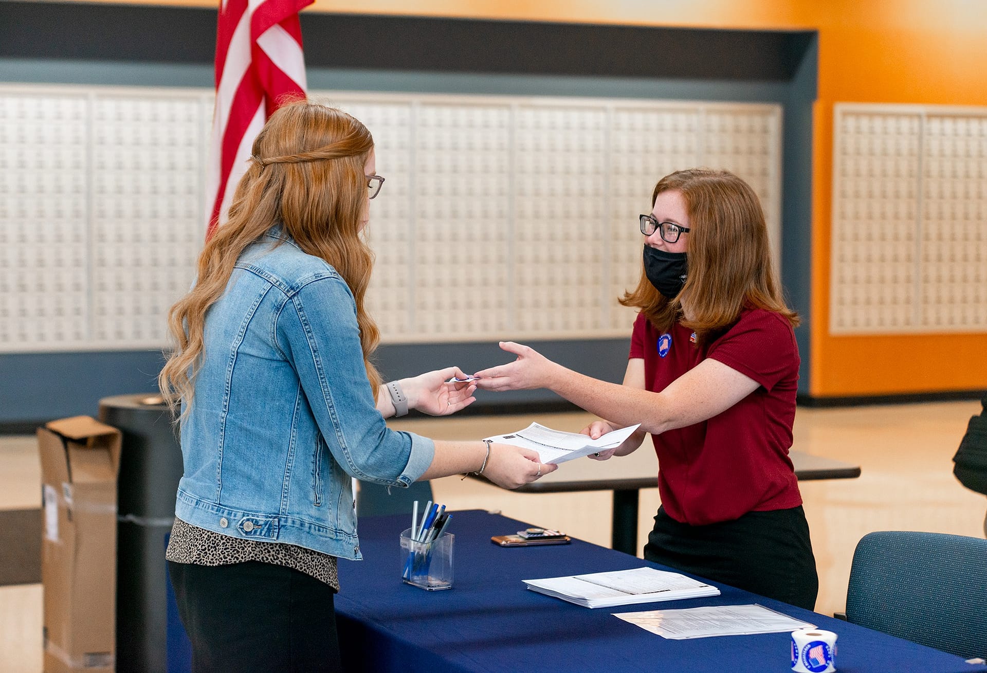 Female student turning in her voter registration form.