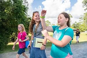 Hannah Doolittle walking with campers at Camp o' the Pines. 