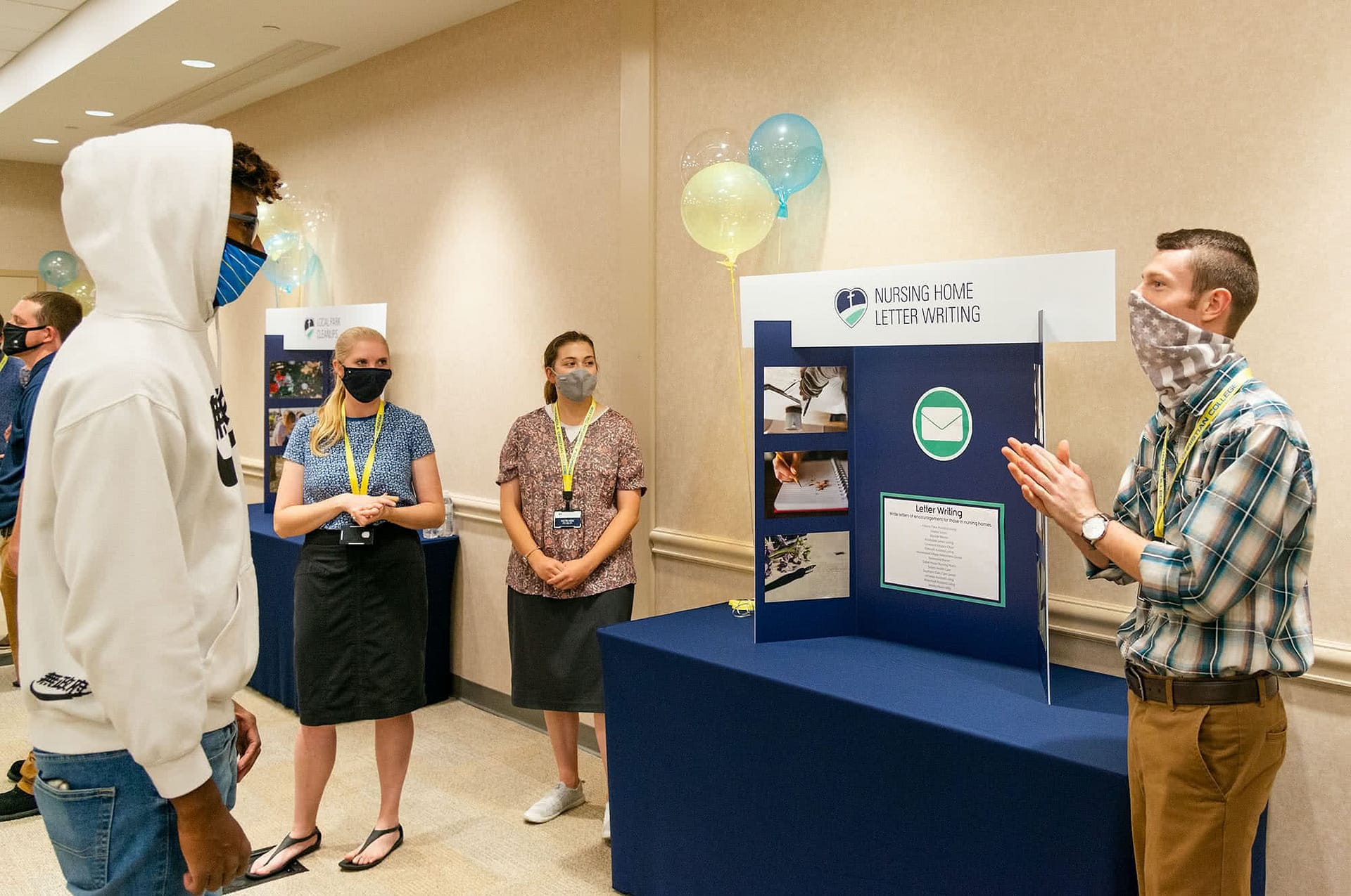 Students discuss joining the "Nursing Home Letter Writing" Christian service group at the Christian Service expo