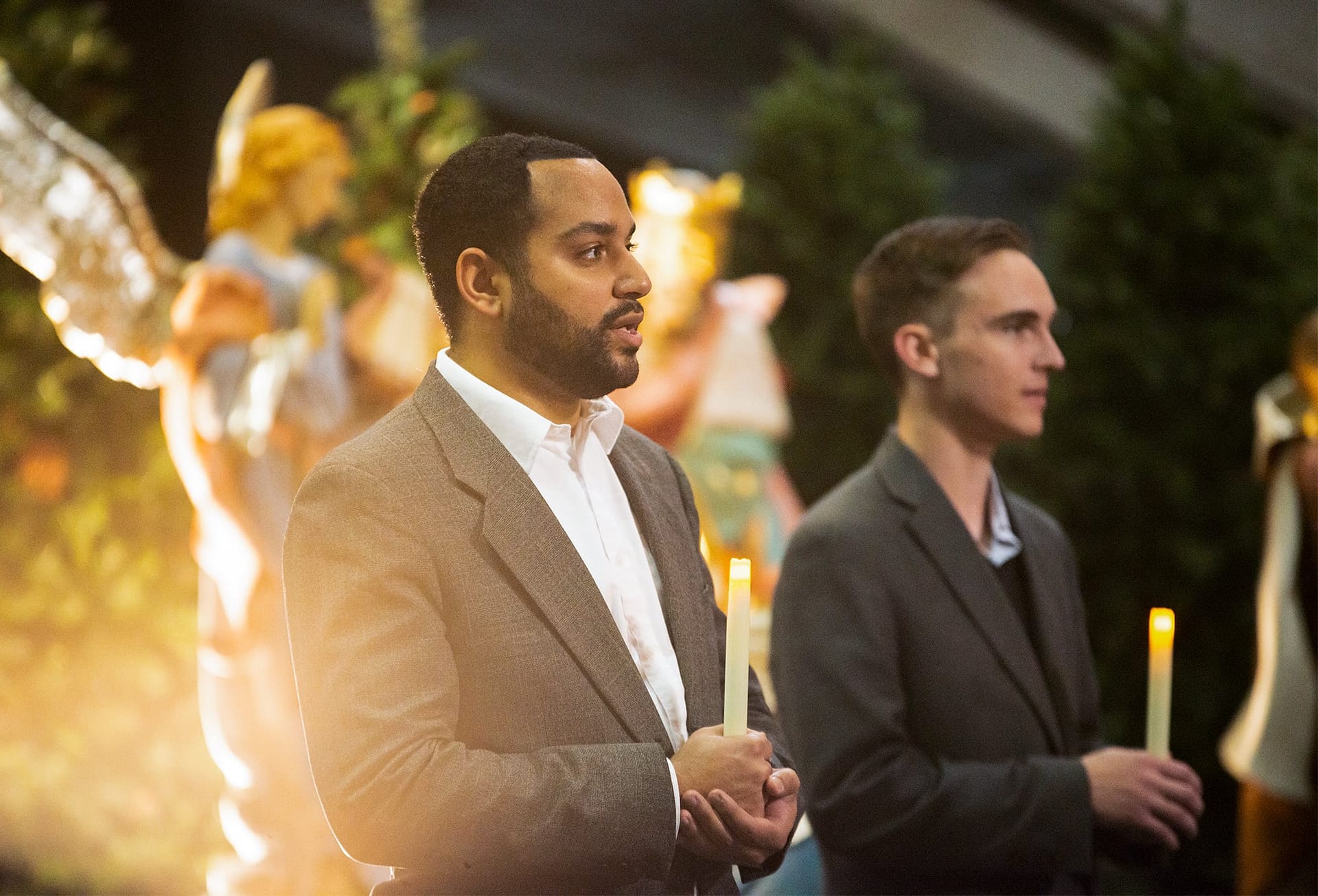 One Accord singers hold candles as they sing
