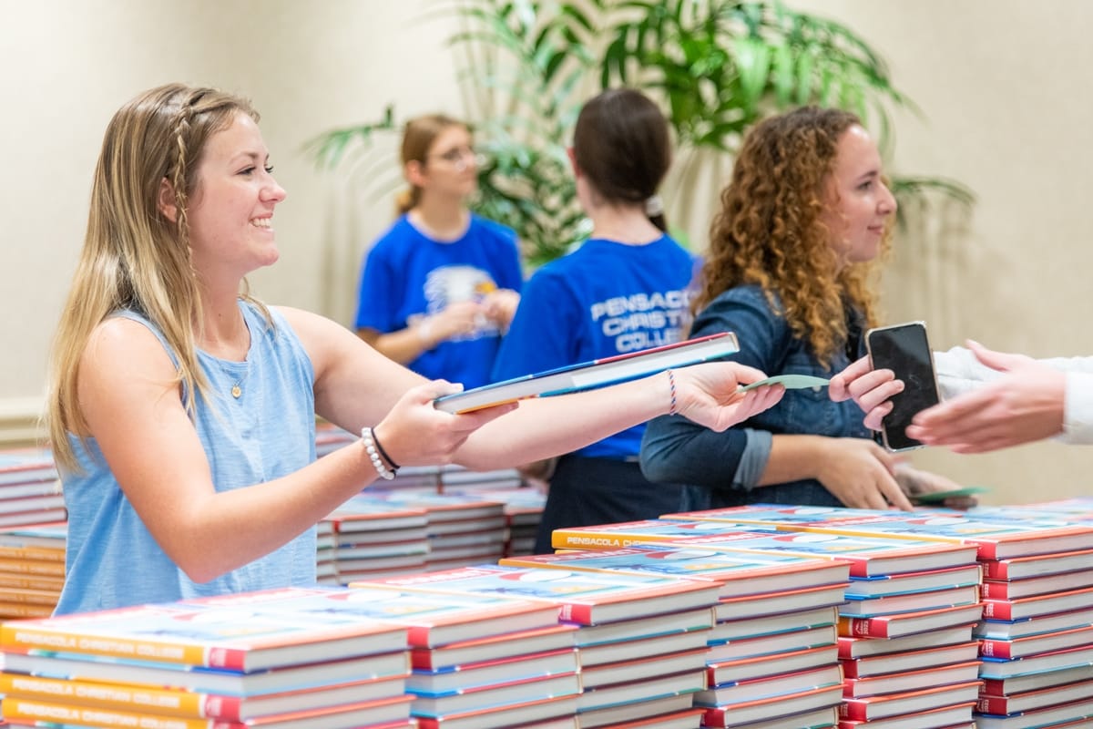 summit-distribution-6 Worker hands out the new 2023 Summit Yearbook