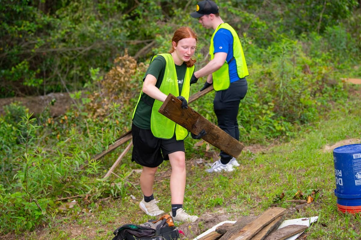 A PCC girl helps clean up at Carpenters Creek through the Serve Pensacola activity