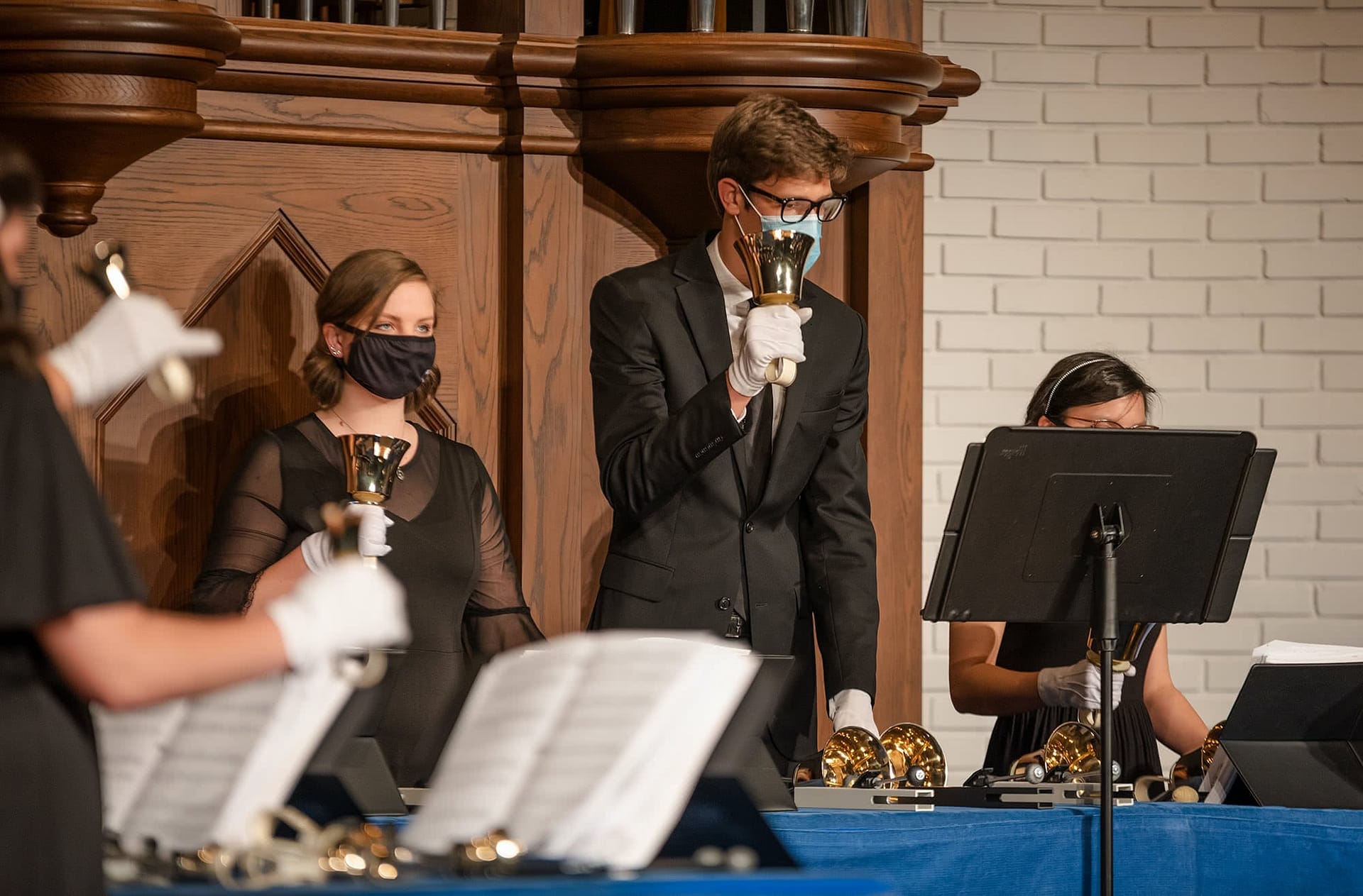 Three students playing handbells at the PCC Handbell Concert.