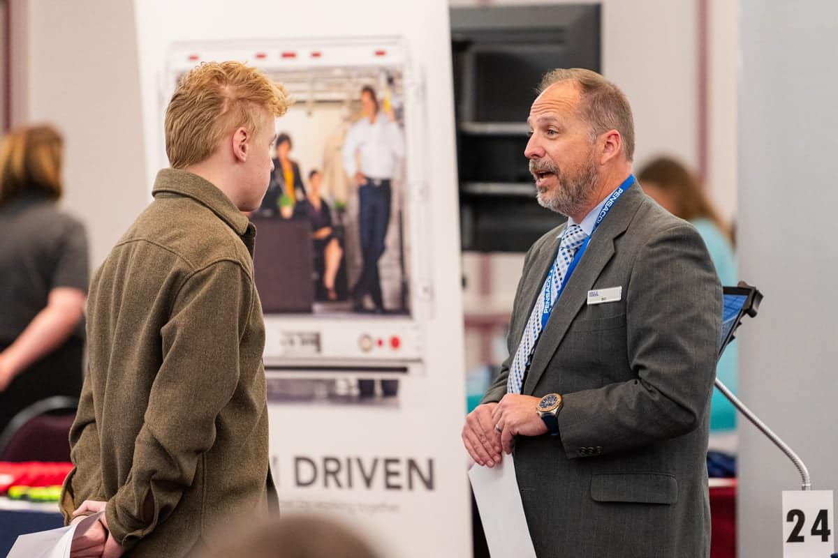 PCC Student listens to Navy Federal Representative at the Career Fair