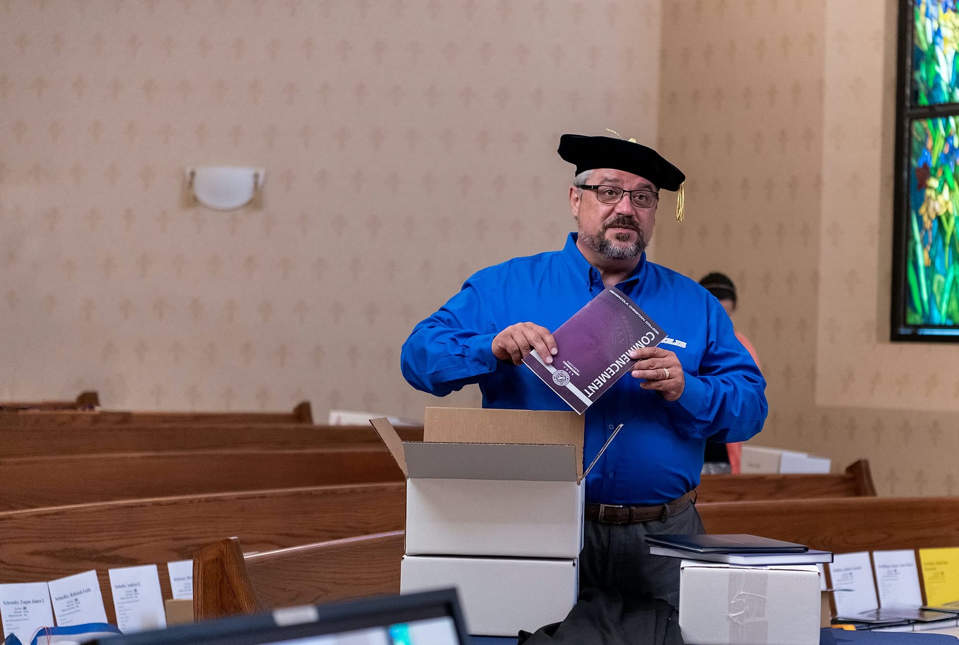 Dr. Shoemaker holding a Commencement 2020 booklet.