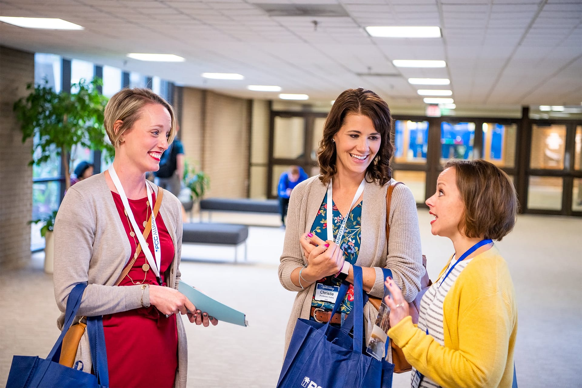 Three female PCC Alumni talking to one another at check-in.