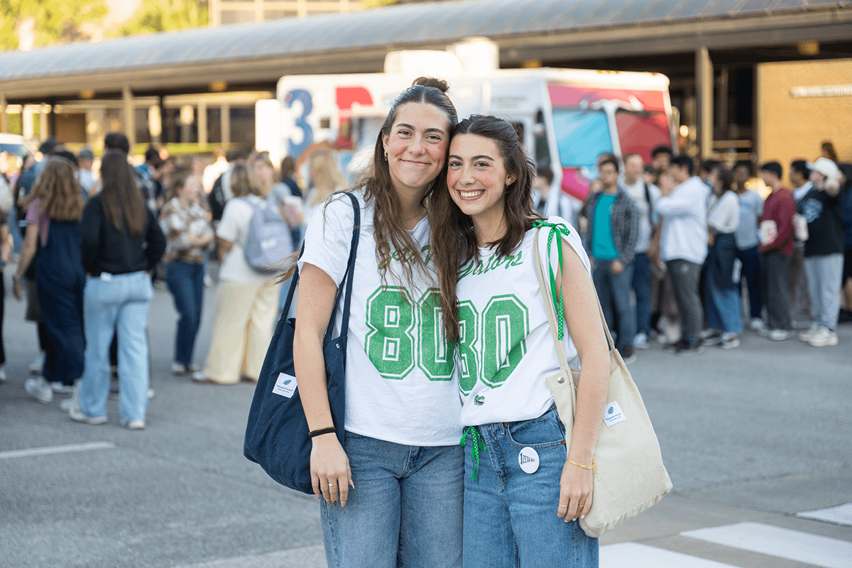 Students pose in front of food trucks